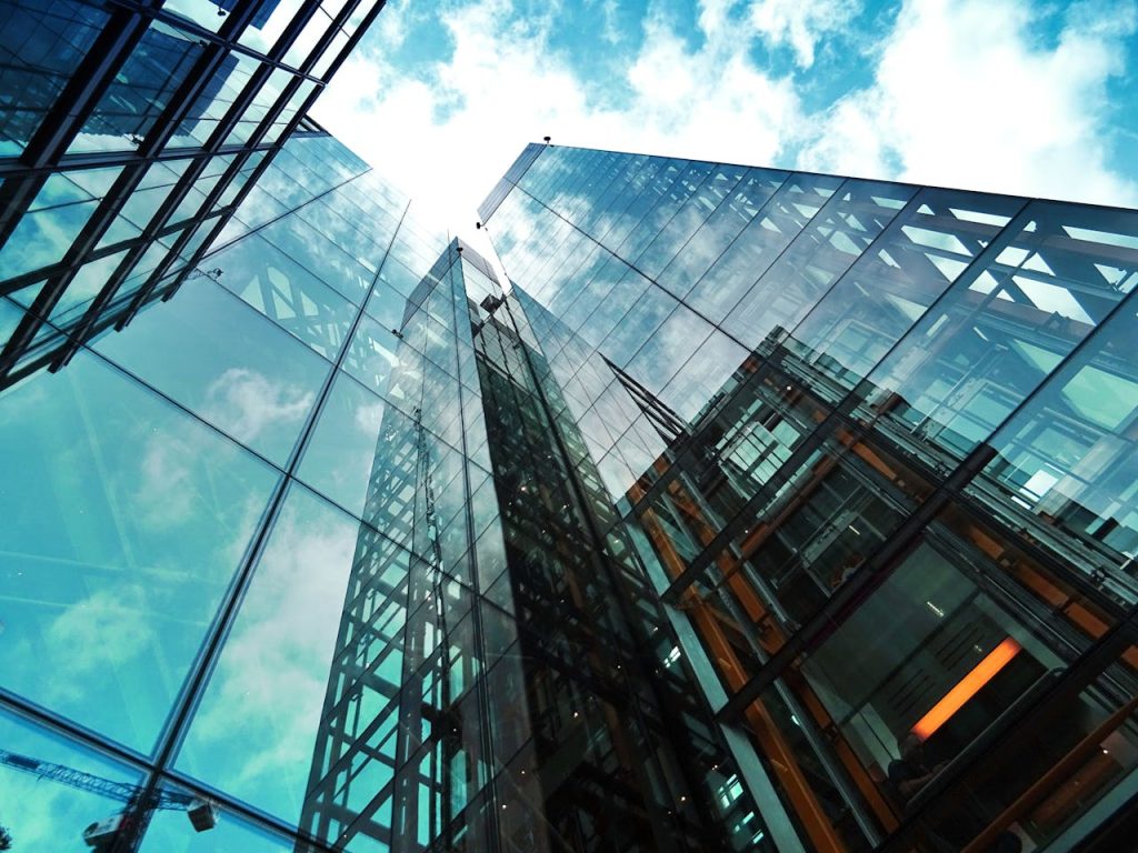 high-rise-buildings-443383 A striking view of a modern glass skyscraper reflecting the sky and clouds.
